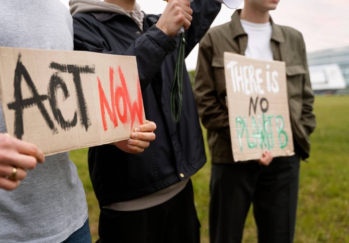 Group holding ACT NOW sign for advocacy